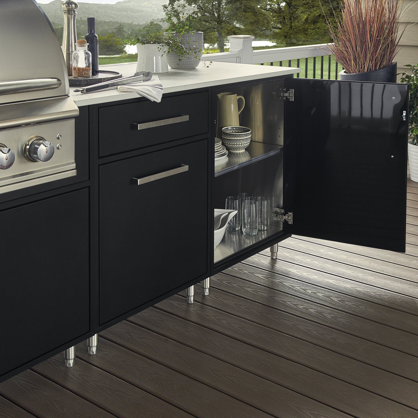 Flat Black outdoor kitchen cabinets with grill, and open cabinet displaying glasses.